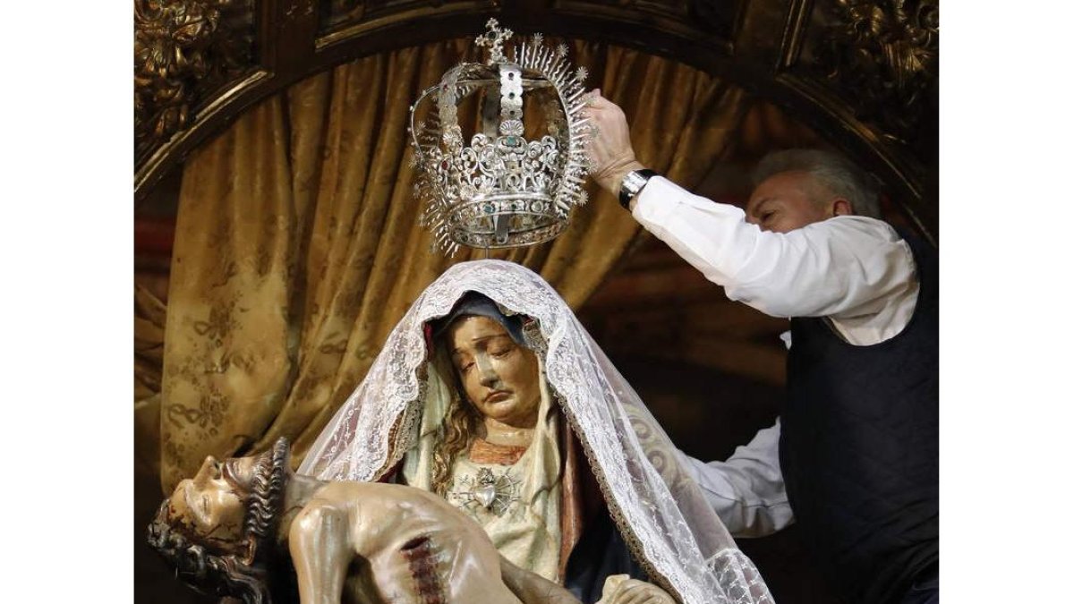 Julio Cayón coloca la corona sobre la imagen de Nuestra Señora del Mercado, durante los preparativos para la procesión de hoy. JESÚS