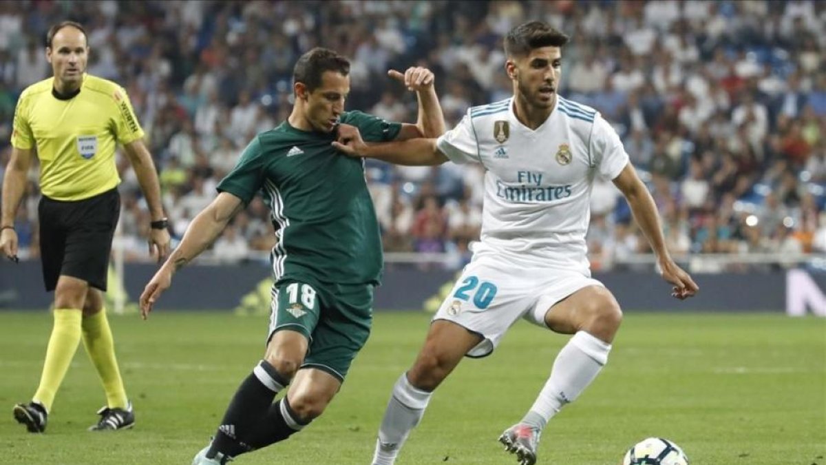 Asensio conduce el balón perseguido por Guardado durante el último Real Madrid-Betis.