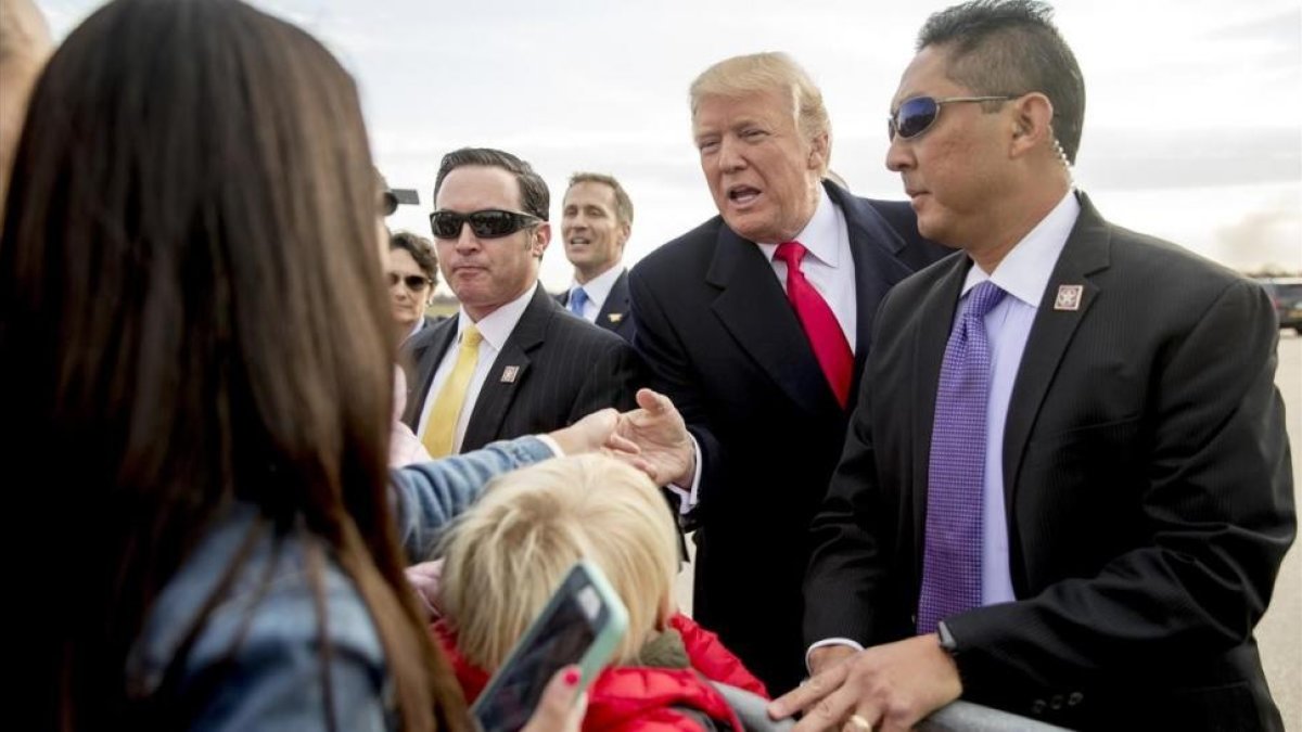 Trump (centro) saluda a varios ciudadanos a su llegada al aeropuerto internacional de Saint Louis, el 29 de noviembre.