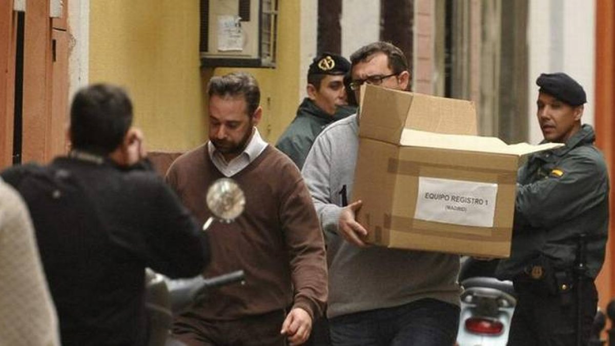 Un funcionario saca una caja de la sede de la UGT Andalucía en la capital sevillana, durante el registro que se está efectuando por parte de agentes de la Unidad Central Operativa (UCO) de la Guardia Civil tras la orden dada por la juez de instrucción 6,