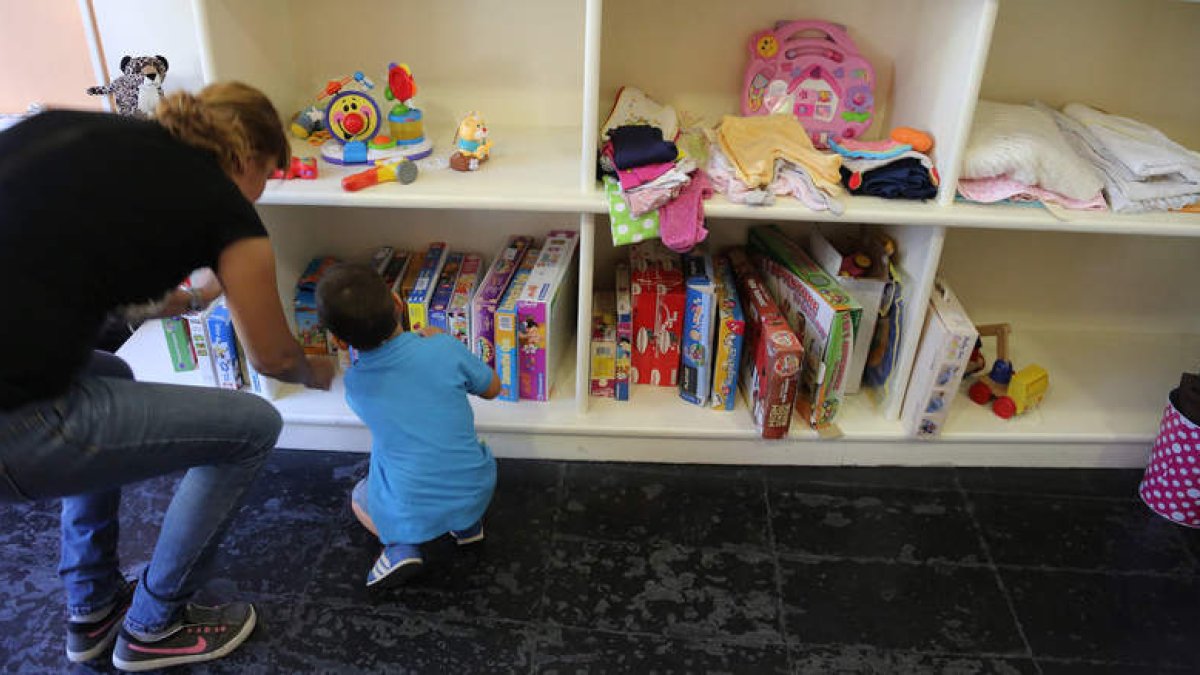 Un padre y su hijo buscan entre los juegos de mesa de la tienda Entre nenes.