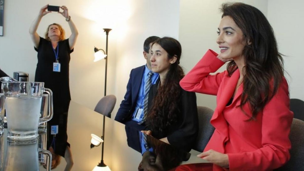 Amal Clooney (de rojo) junto a Nadia Murad, este lunes en Naciones Unidas, durante una entrevista con el ministro de asustos exteriores francés Jean-Marc Ayrault.