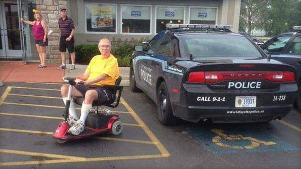 Un agente estaciona el vehículo de la policía en una plaza de discapacitados mientras desayuna.