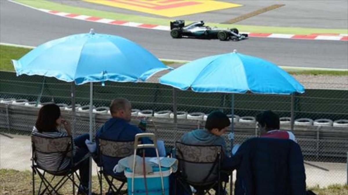 Una familia sigue la competición clasificatoria, ayer, en el circuito de Montmeló.