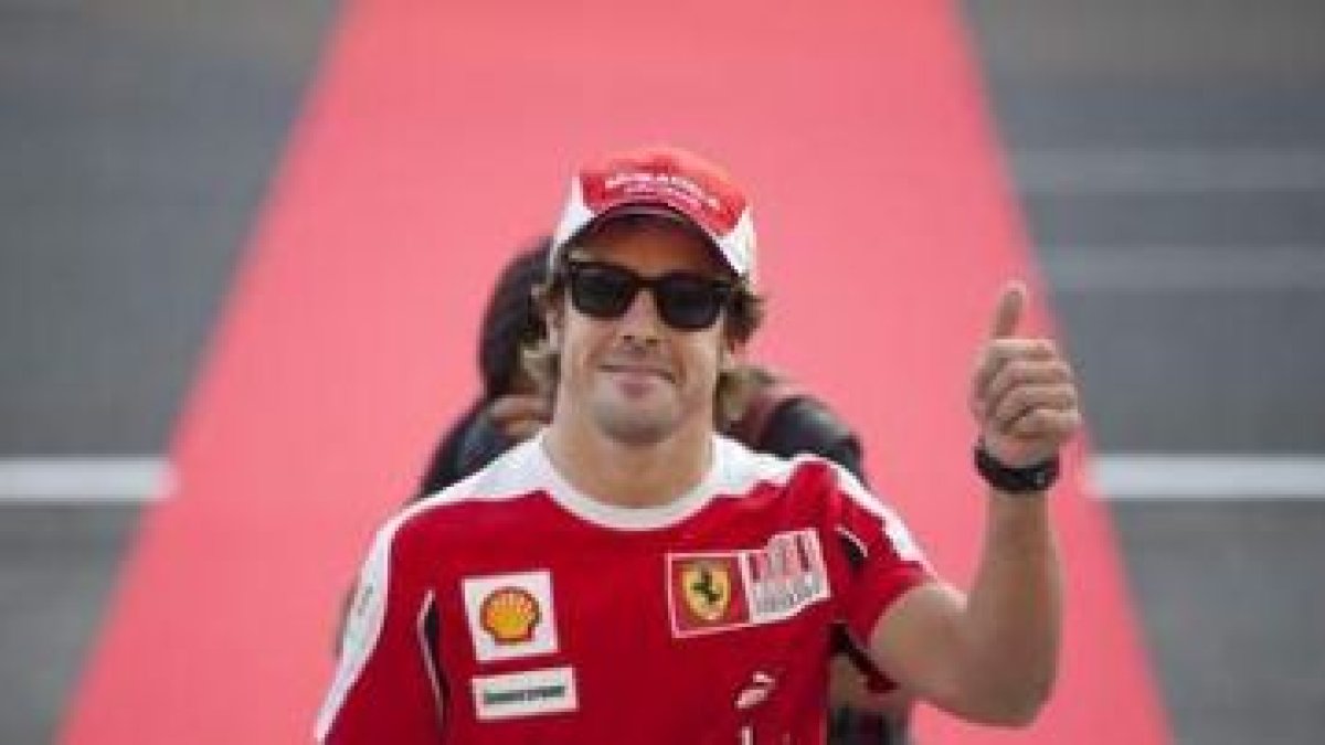 Fernando Alonso saluda a sus aficionados sobre la alfombra roja de Suzuka.