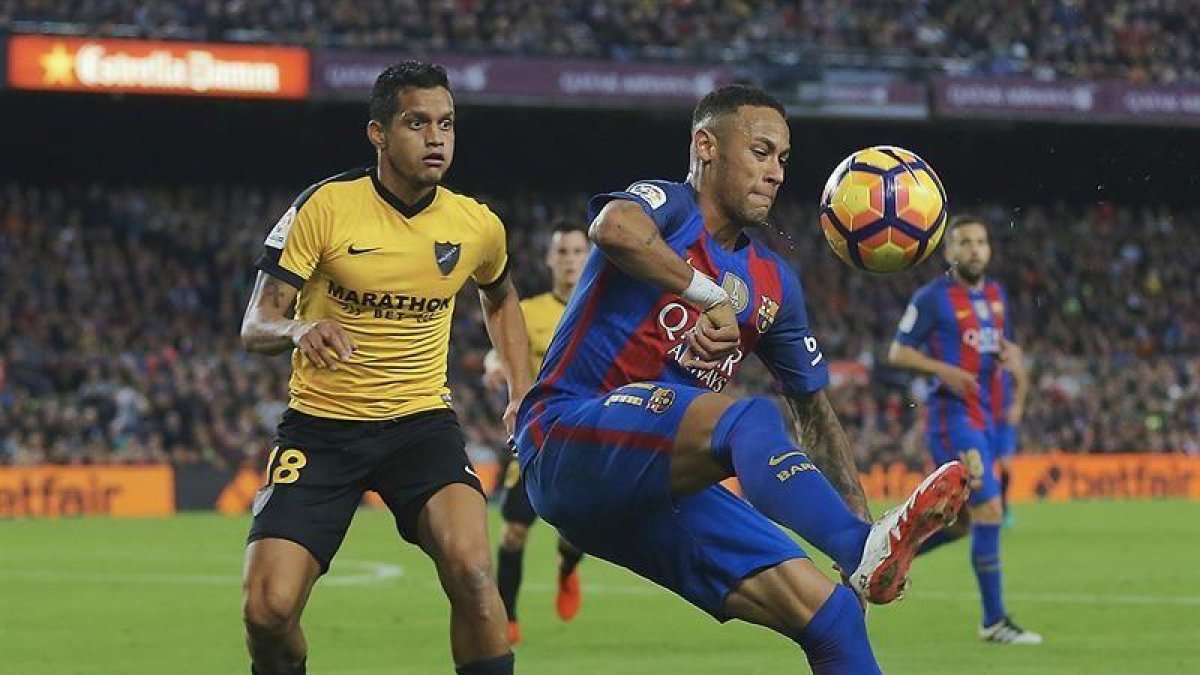 El delantero brasileño del FC Barcelona Neymar Jr. (d) y el defensa venezolono Roberto Rosales (i), durante el partido de la duodécima jornada de Liga de Primera División.
