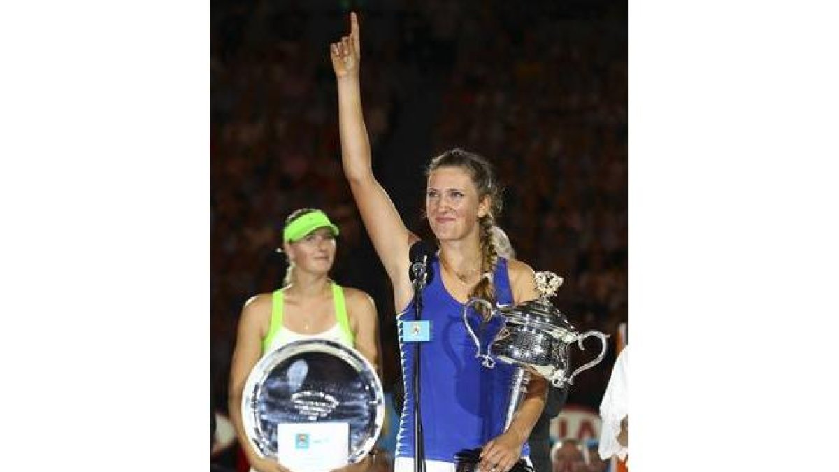 Victoria Azarenka tras recibir el trofeo que la acredita como ganadora del Abierto de Australia. Tras ella, Maria Sharapova.
