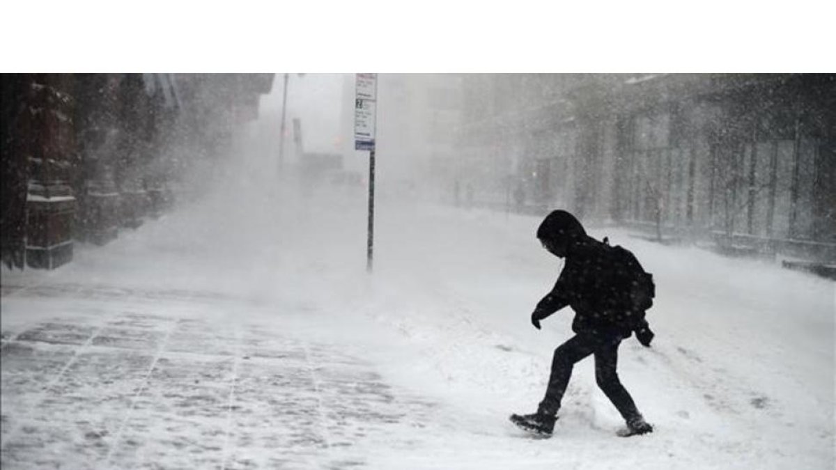 Un neoyorquino intenta avanzar a través de la tormenta de nieve en la ciudad.