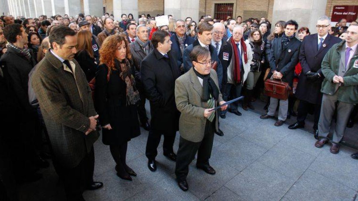 El juez decano de Zaragoza lee el manifiesto de la concentración flanqueado por representantes de los operadores judiciales, el pasado jueves.