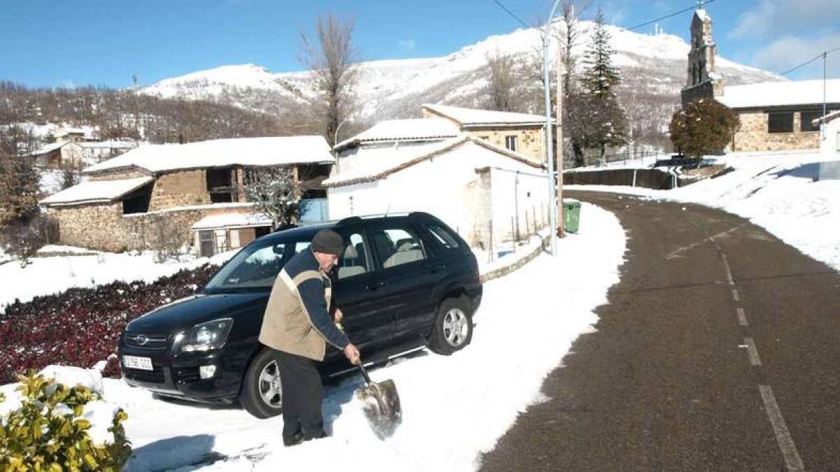 Un hombre aparta la nieve con una pala antes de sacar el coche.