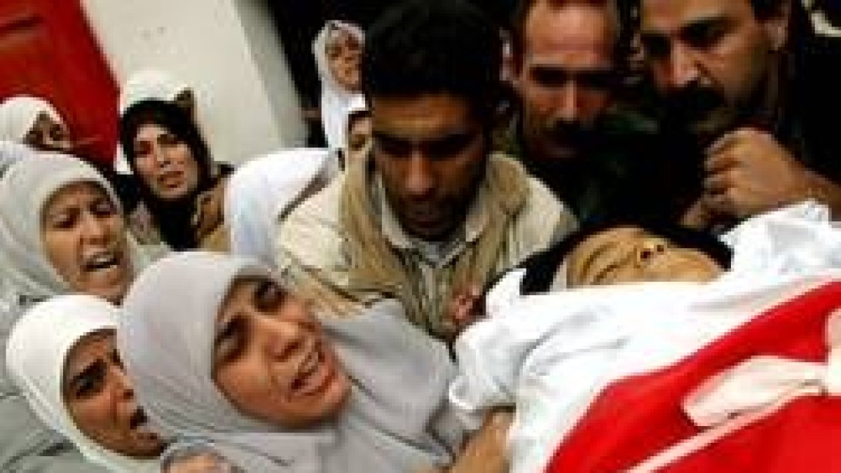 La madre y el padre de Ahmed lloran sobre su cadáver acompañados por toda su familia