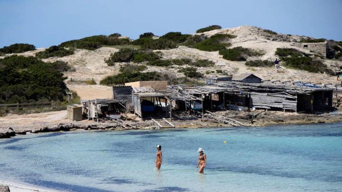 Dos personas se bañan en la playa de ses Illetes en Formentera.