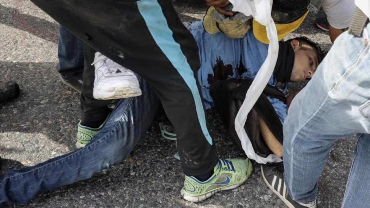 El joven David José Vallenilla es atendido tras recibir el disparo.