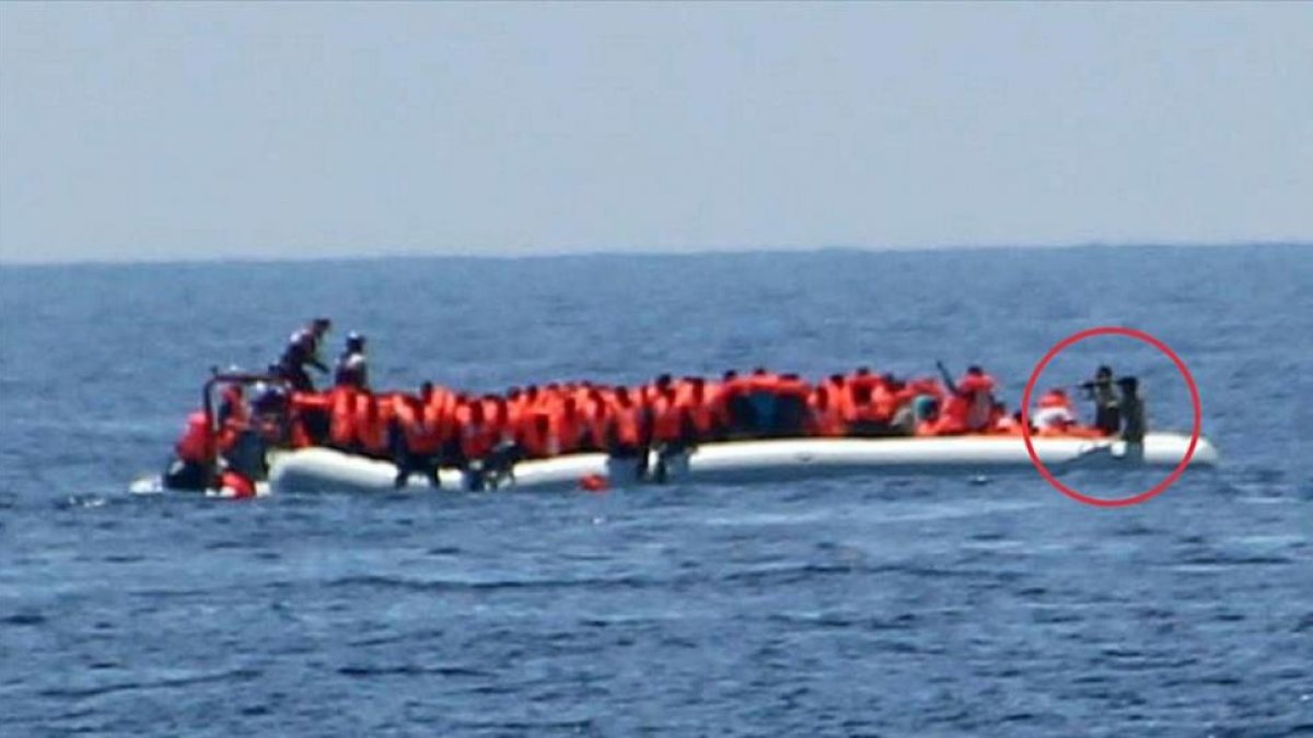 Imagen de la oenegé Jugen Rettet donde se ve a unos guardacostas libios apuntando a unos refugiados.