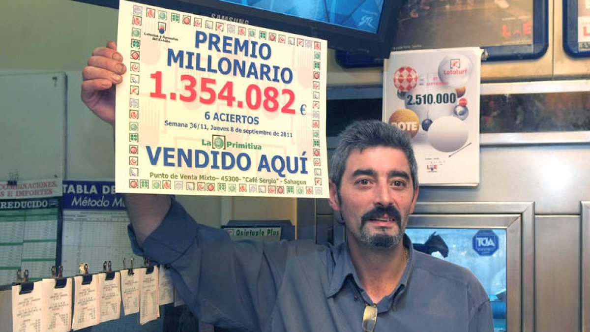 El gerente del bar Sergio, Francisco Fernández, muestra el cartel con el premio.