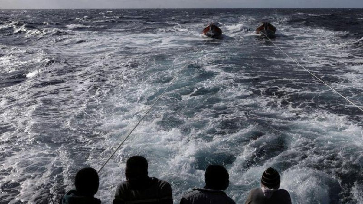 Inmigrantes en la popa del 'Golfo Azzurro', en dirección hacia Sicilia, al día siguiente de ser rescatados por la oenegé Proactiva Open Ams, el 3 de enero.