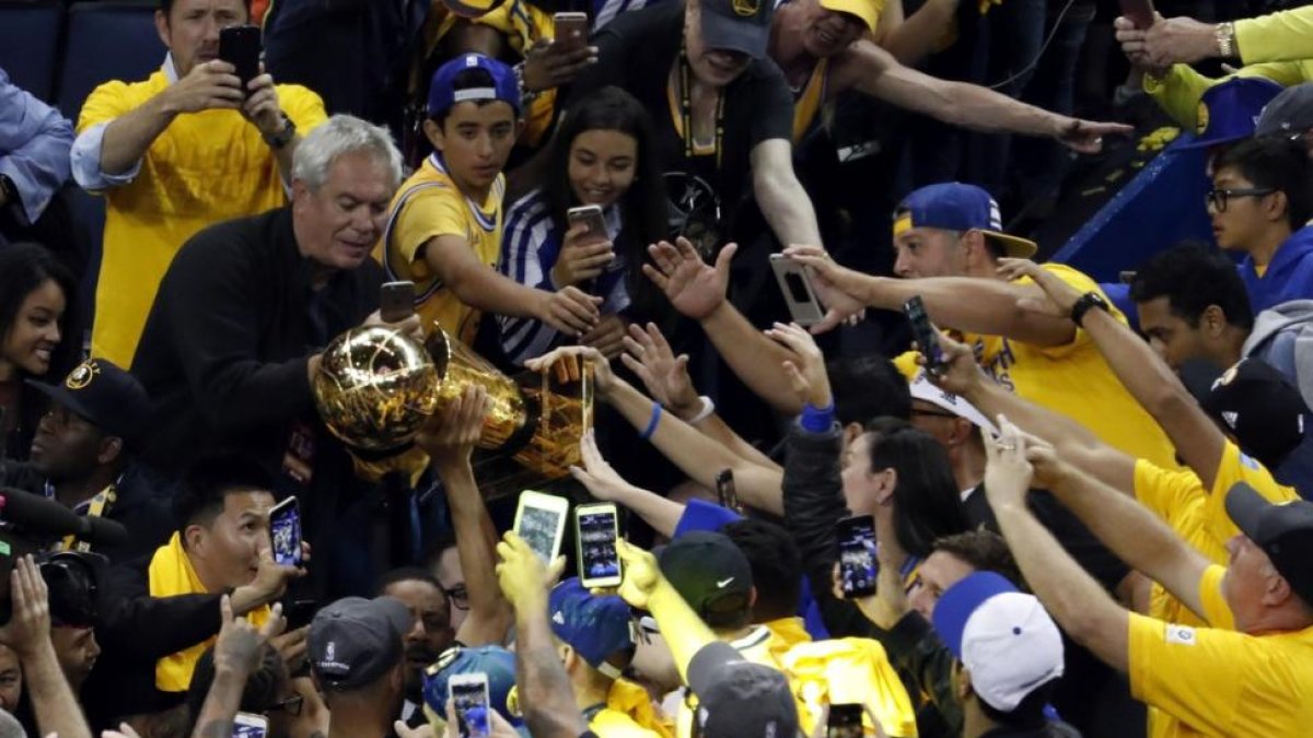 Stephen Curry alza el trofeo de la NBA.