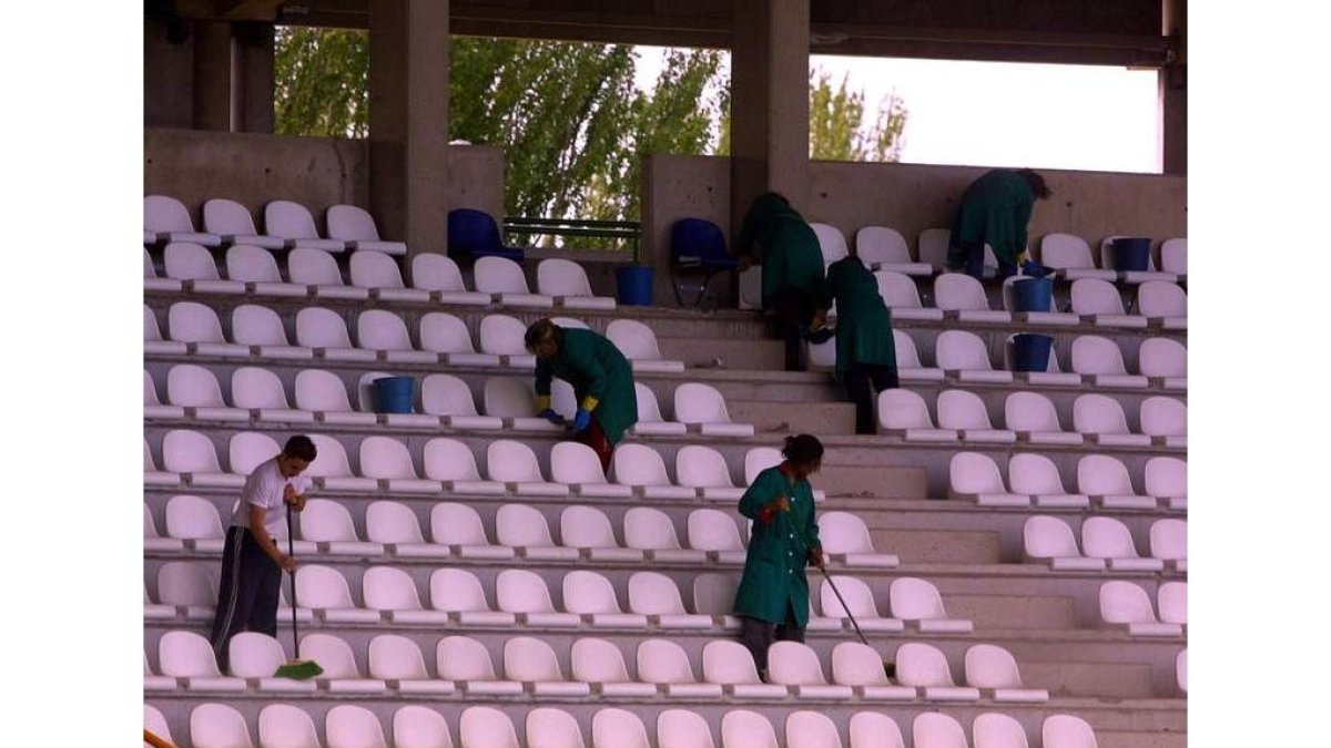 Empleados de interiores en un trabajo de limpieza del campo de fútbol.