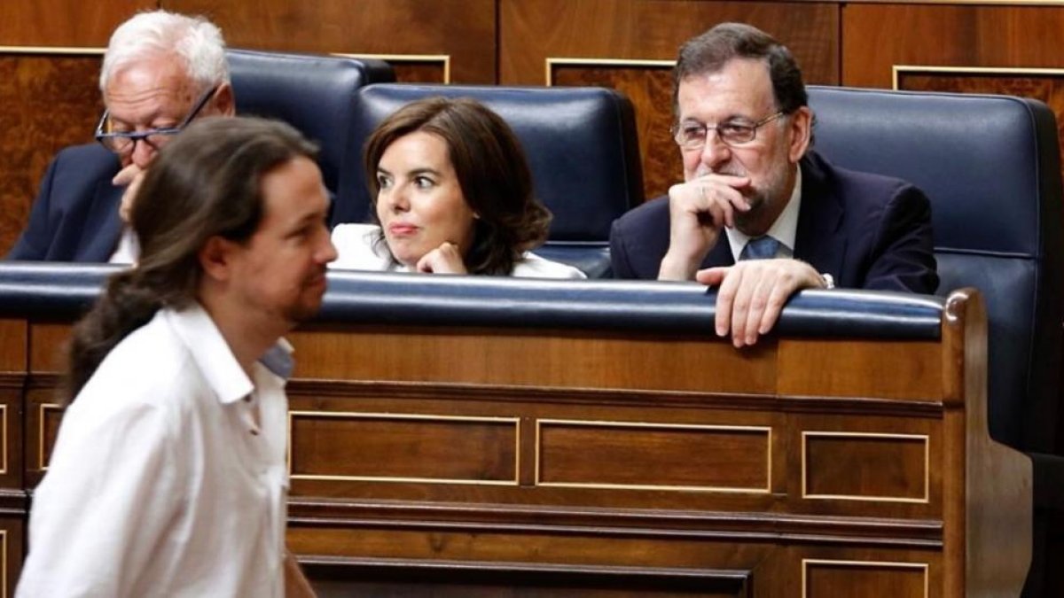 Pablo Iglesias pasa ante Mariano Rajoy mientras se dirige a votar en el acto de constitución de la XII legislatura.