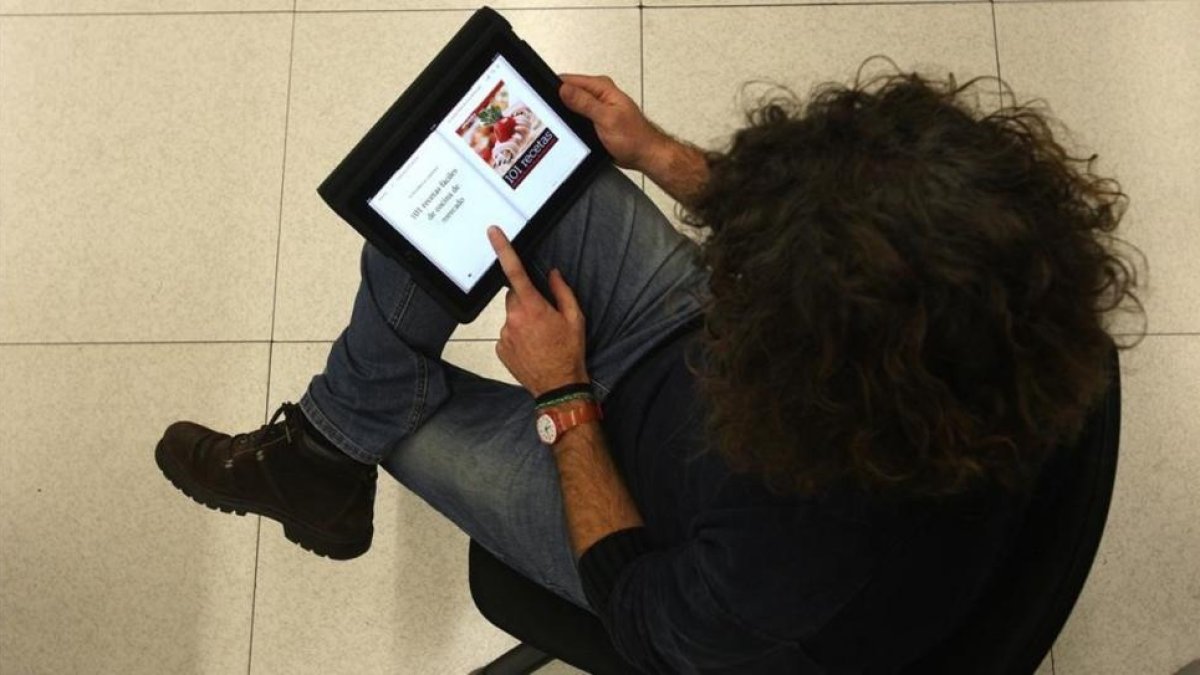Una lectora, consultando un libro de recetas en una tablet.