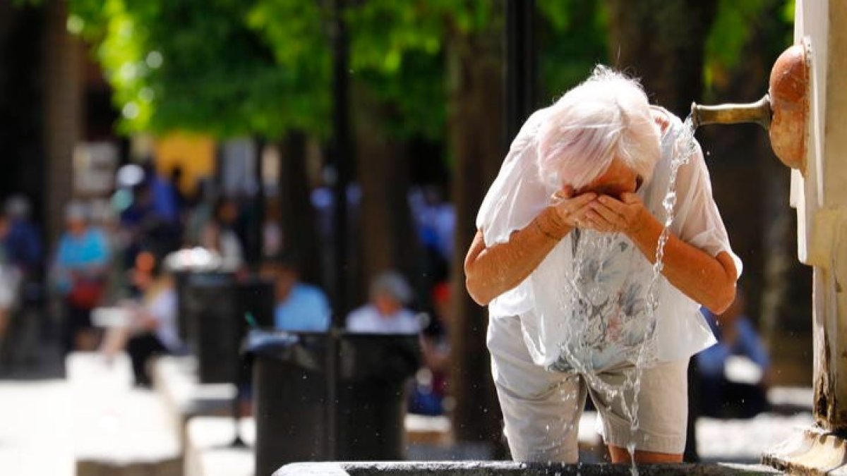 Una mujer se refresca en una fuente de  debido al calor sofocante más propio del mes de julio. SALAS