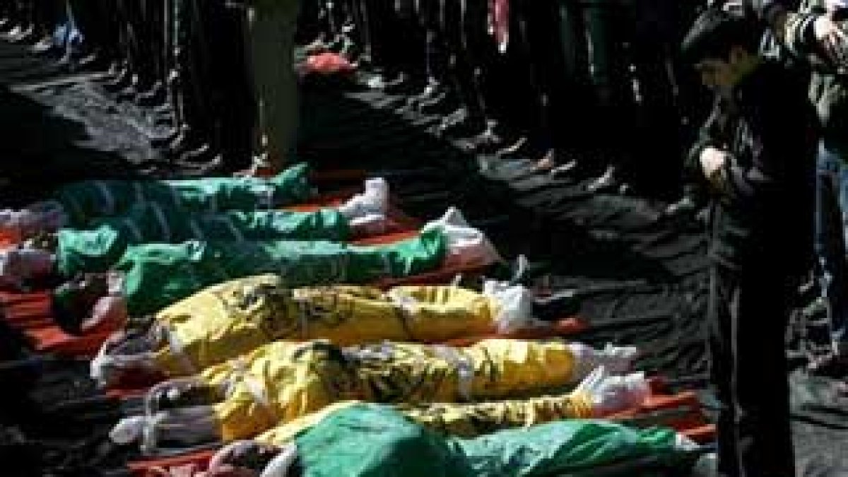 Numerosos palestinos rezan junto a los cuerpos de los 43 palestinos asesinados en un ataque israelí.