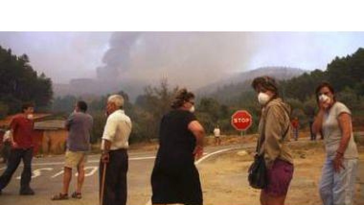 Vecinos de Las Vegas de Coria (Cáceres) observan el incendio forestal.