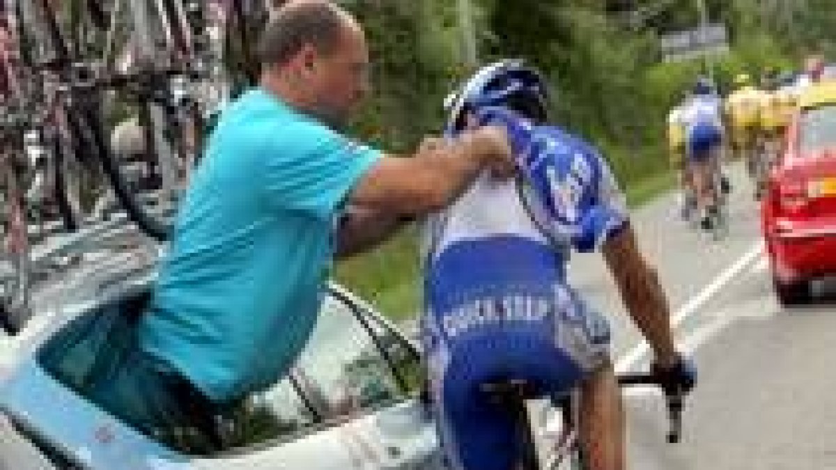 Un técnico revisa la radio de uno de los ciclistas durante la carrera