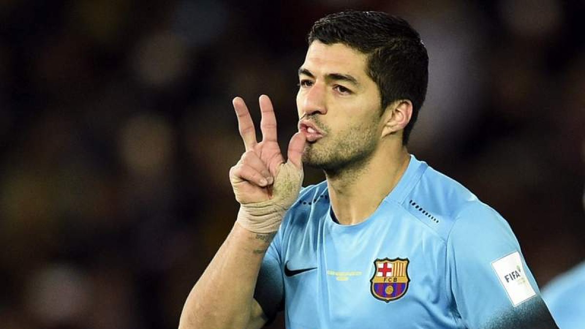 Suárez extiende tres dedos para ilustrar el hat-trick que hizo ayer ante los chinos.
