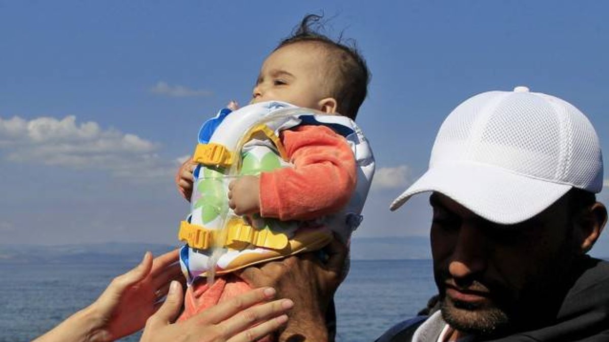 Un bebé llega a la isla griega de Mytilini tras salir de Turquía, este domingo.