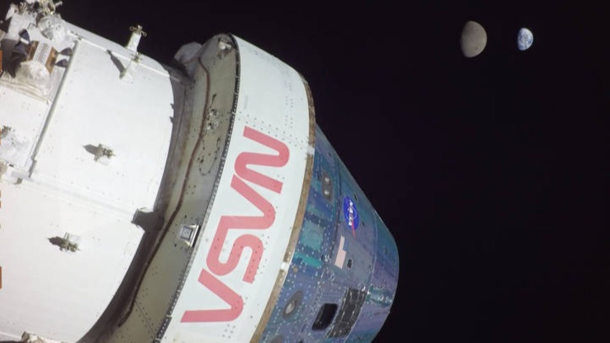 Fotografía del 28 de noviembre que muestra a la cápsula Orión de la misión Artemis I al momento de alcanzar una distancia de 432.210 kilómetros (268.563 millas) y al fondo la Luna y la Tierra. NASA