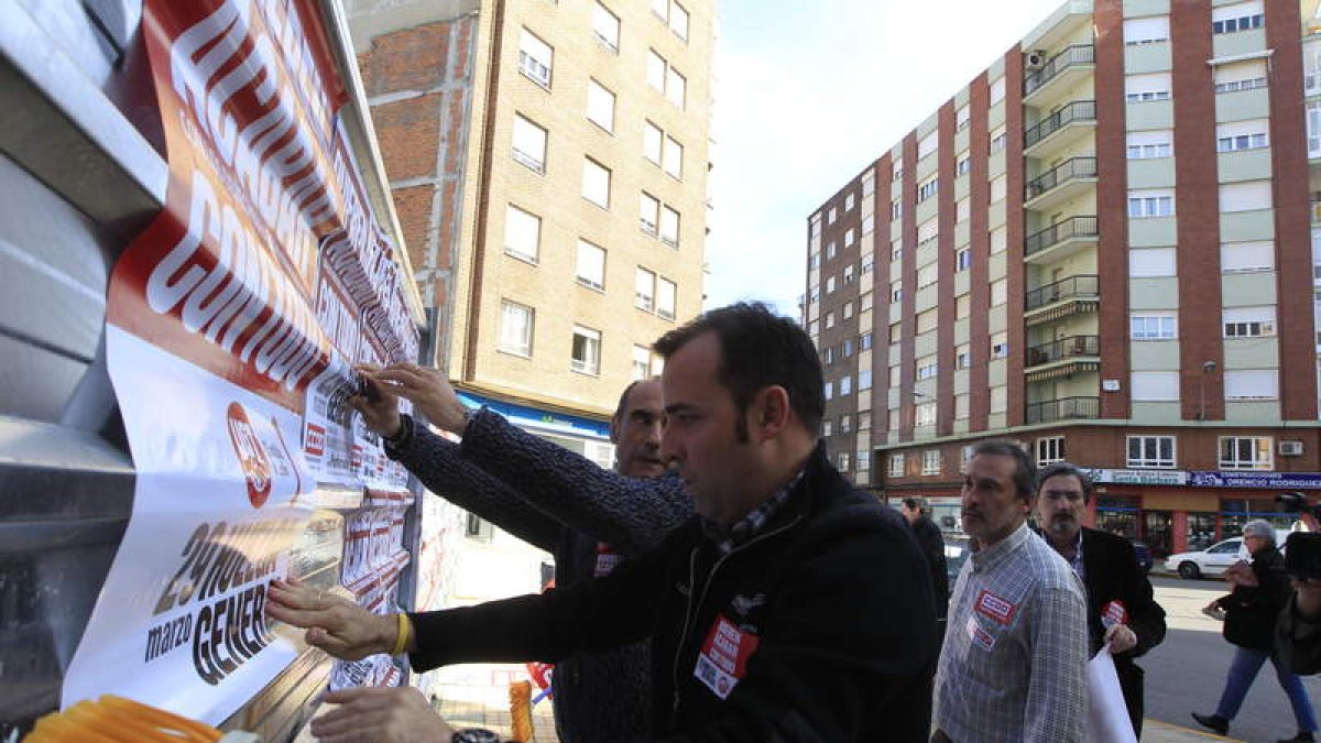 Sindicalistas en una simbólica pegada de carteles.