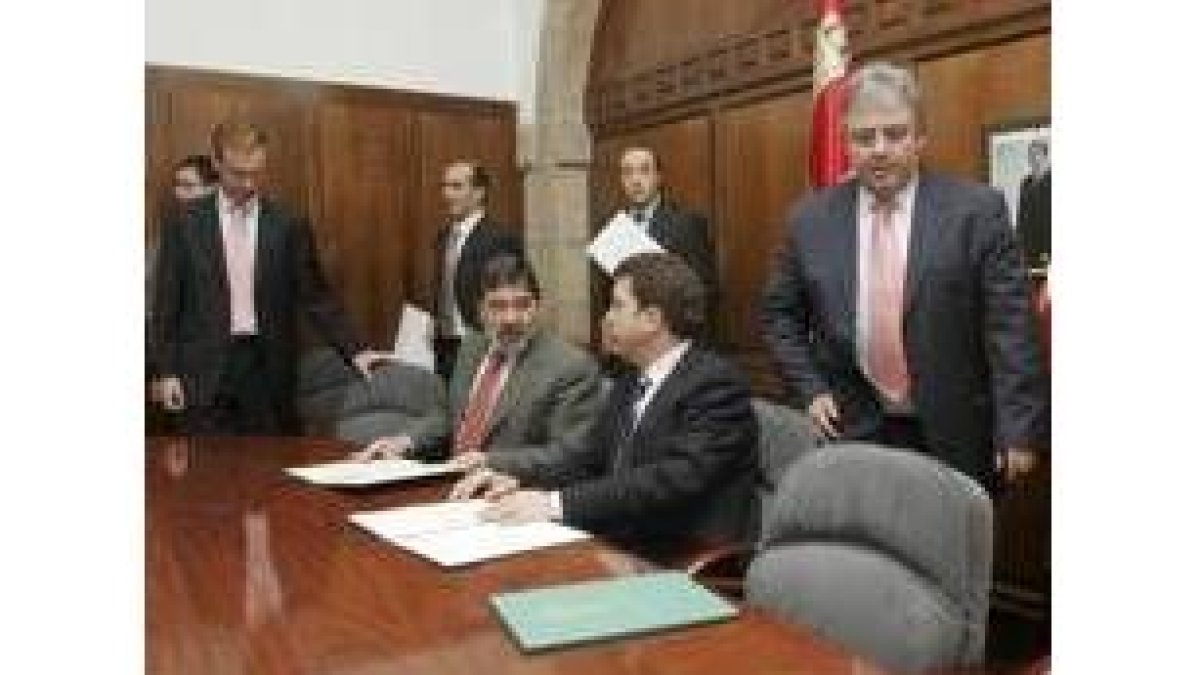 Herráez y Macías (de pie) con Penas y Riesco en la firma del convenio