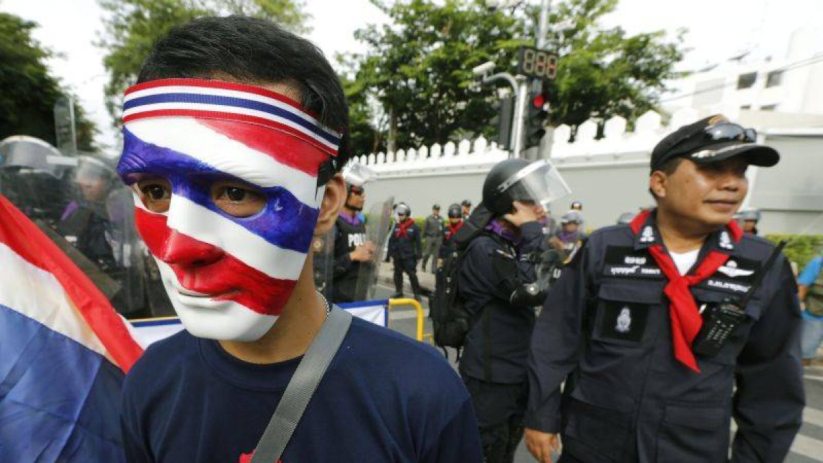 Un manifestante lleva una máscara con los colores de la bandera tailandesa durante la manifestación convocada en los alrededores del Parlamento en Bangkok.