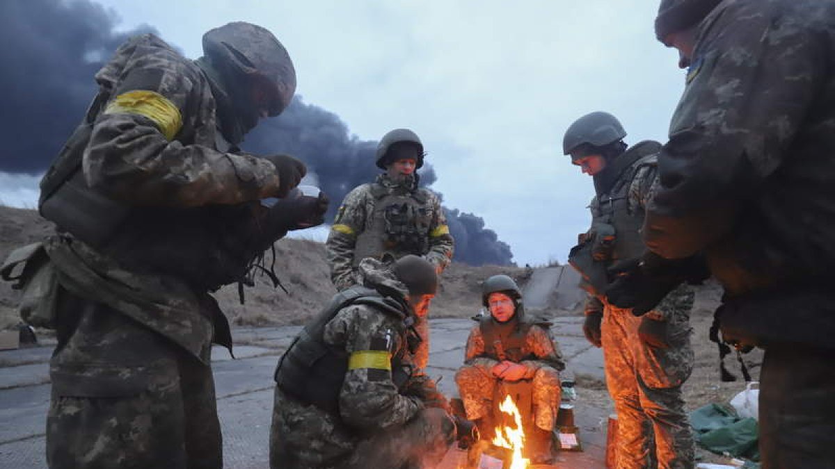 Soldados ucranianos se calientan en una hoguera en las inmediaciones de Kiev a la espera del ataque ruso. ALISA YAKUBOVYCH