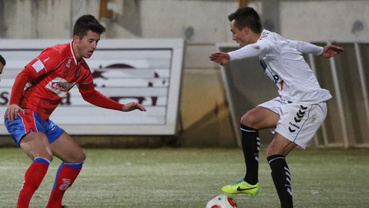 El centrocampista faberense de la Cultural Adán Gurdiel trata de zafarse del jugador del Ourense Pinillos en un lance del partido disputado en el estadio Reino de León.