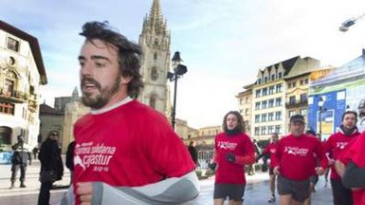 Fernando Alonso pasa frente a la Catedral de Oviedo durante su participación en la carrera solidaria