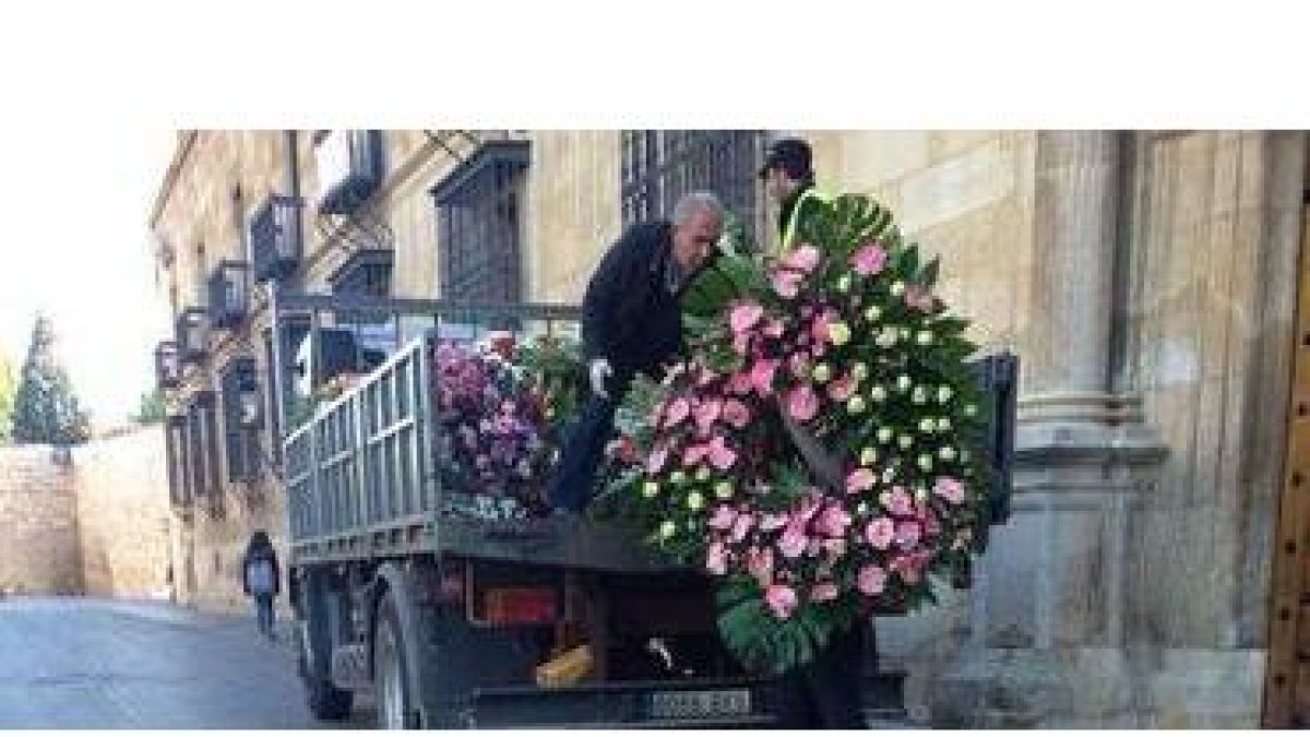 Trabajadores de la Diputación retiran en un camión las coronas de flores que se acumulan en el Palacio de los Guzmanes