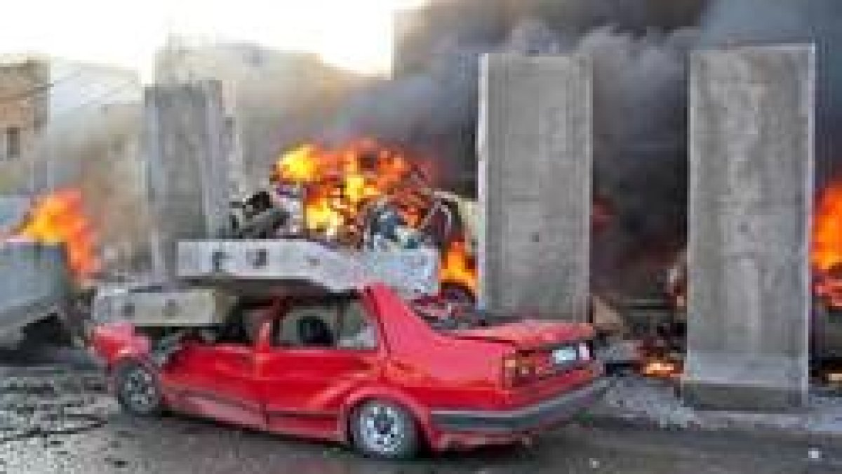 Un vehículo arde tras la explosión que destrozó los alrededores de una comisaría iraquí en Mosul