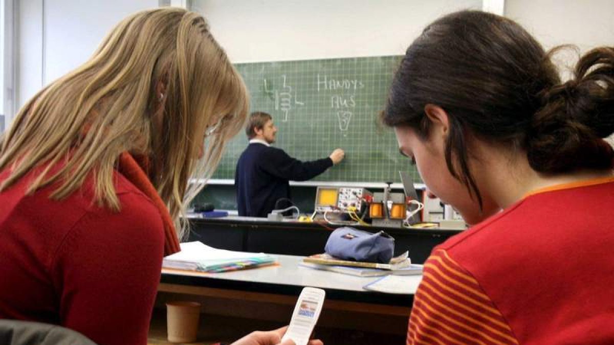 Dos estudiantes se distraen echando un vistazo al móvil durante una clase. MARKUS FUERER