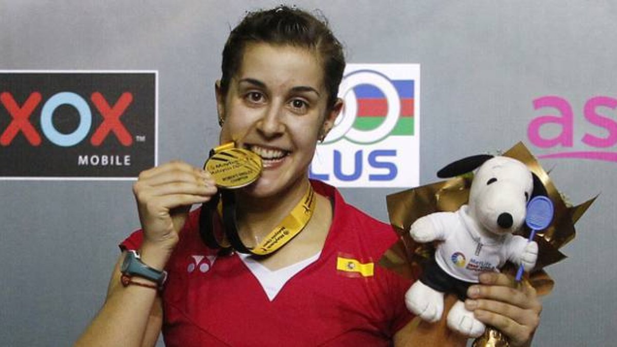 Carolina Marín 'muerde' la medalla de oro que la acredita como ganadora del Abierto de Malasia de bádminton.