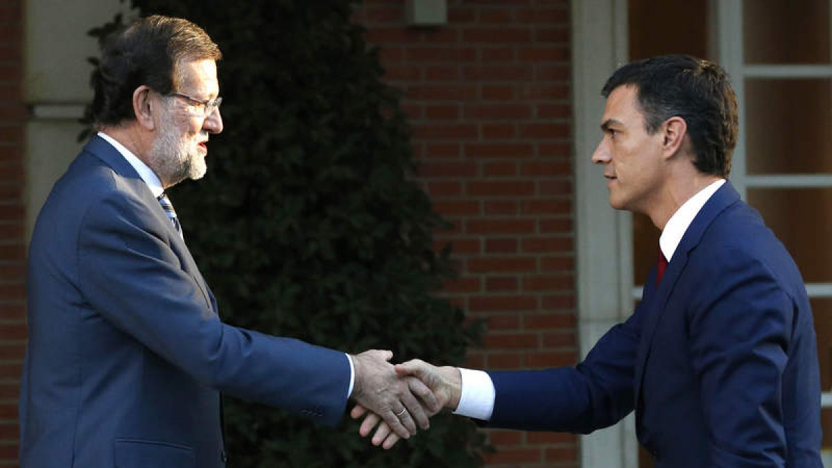 Mariano Rajoy saluda al secretario general del PSOE, Pedro Sánchez, en la escalinata del palacio de La Moncloa