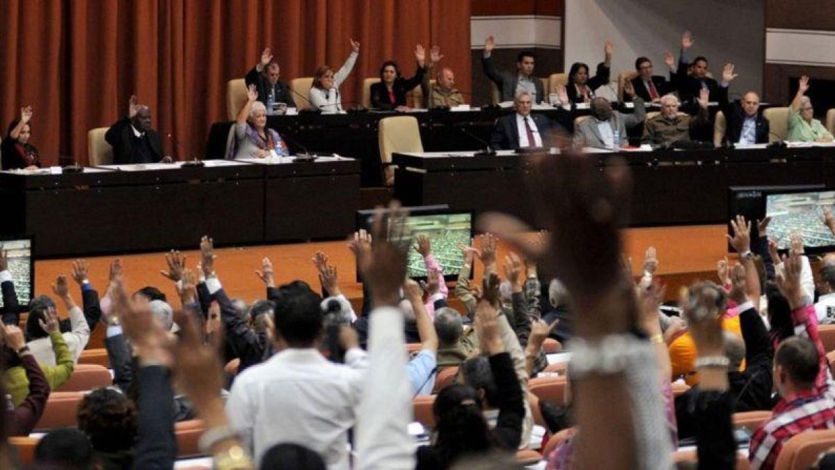Diputados de la Asamblea Nacional de Cuba ejercen su derecho al voto durante la sesion plenaria celebrada el 22 de diciembre en el Parlamento, en La Habana.