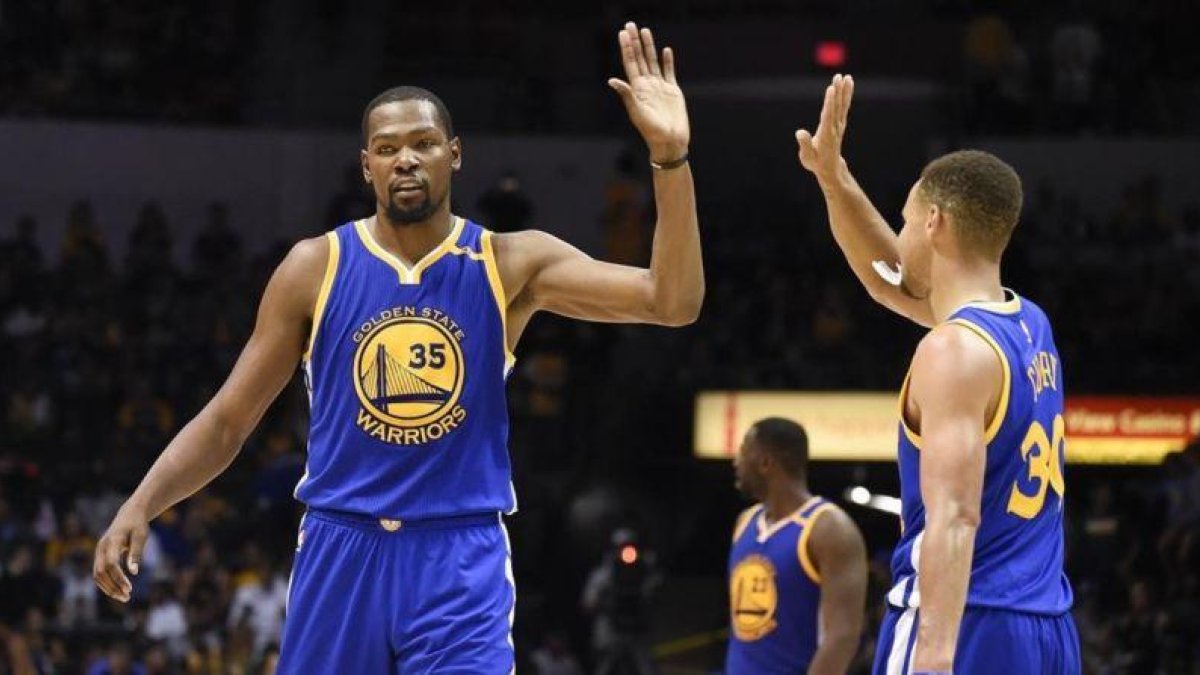 Kevin Durant choca con Stephen Curry durante un partido reciente.