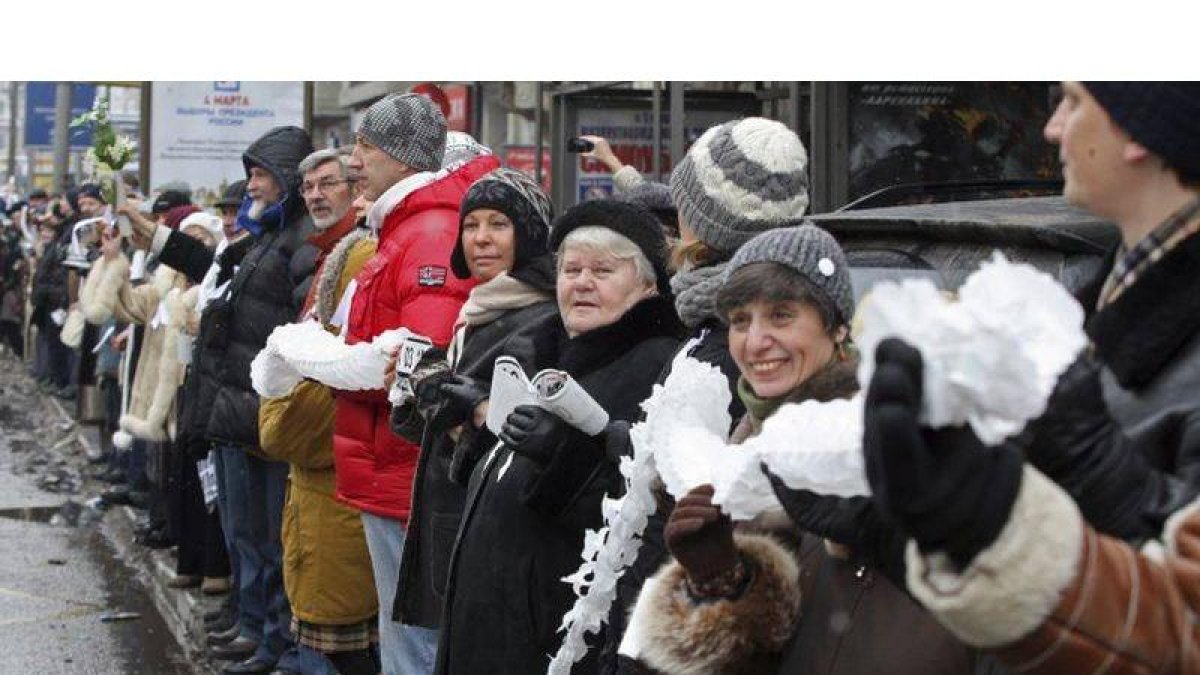 Varias personas permanecen en fila al borde una carretera de Moscú (Rusia) para protestar hoy, domingo 26 de febrero de 2012 contra las supuestas irregularidades cometidas en las elecciones parlamentarias rusas de pasado mes de diciembre y para pedir unos