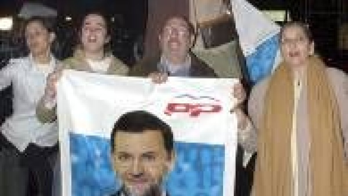 Un grupo de simpatizantes anima a Rajoy ante la sede del PP