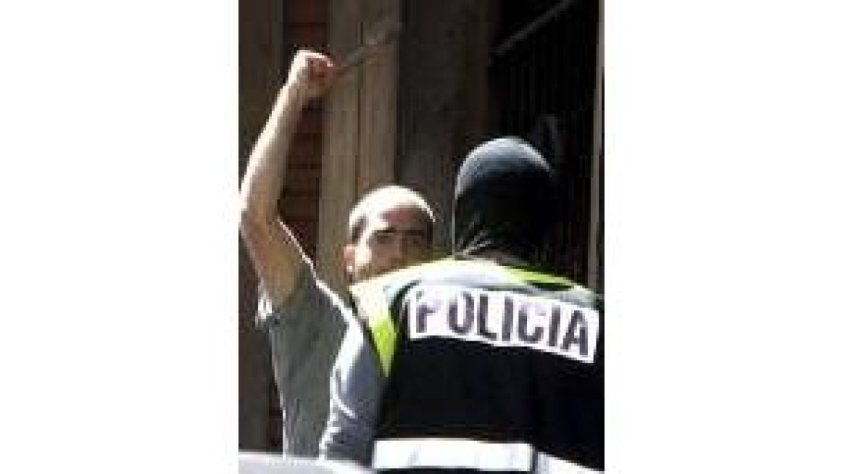Un simpatizante de ANV junto a un policía en la sede clausurada