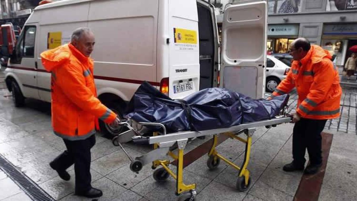 Efectivos del Instituto de Medicina Legal de León se llevan el cadáver.