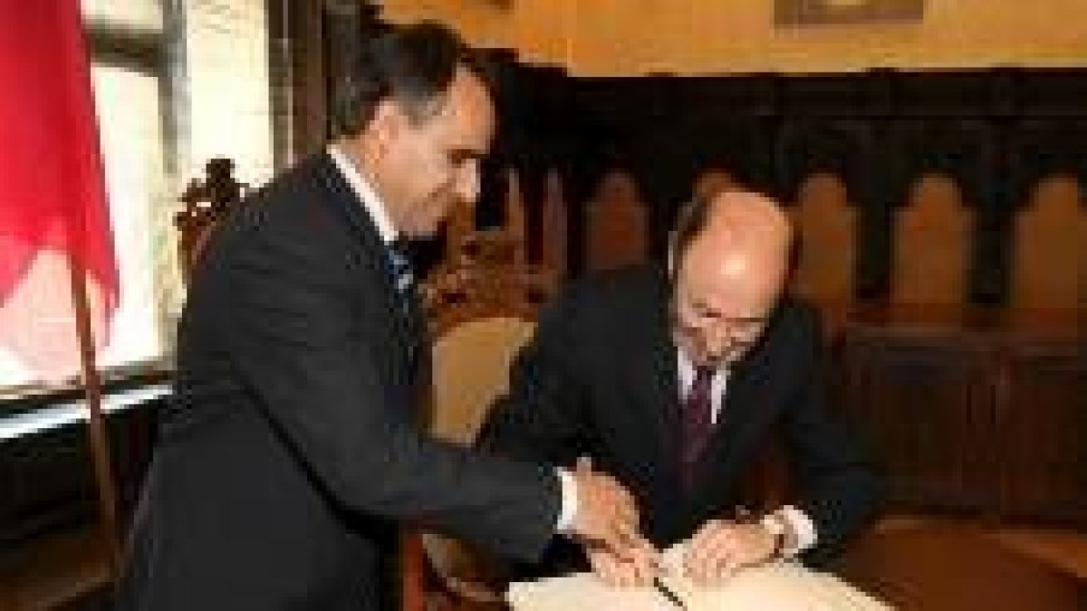 Rubalcaba firma en el libro de honor del ayuntamiento ante la mirada de Perandones