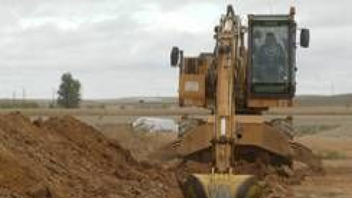 Una excavadora trabaja en la modernización de los regadíos en la zona de Los Oteros